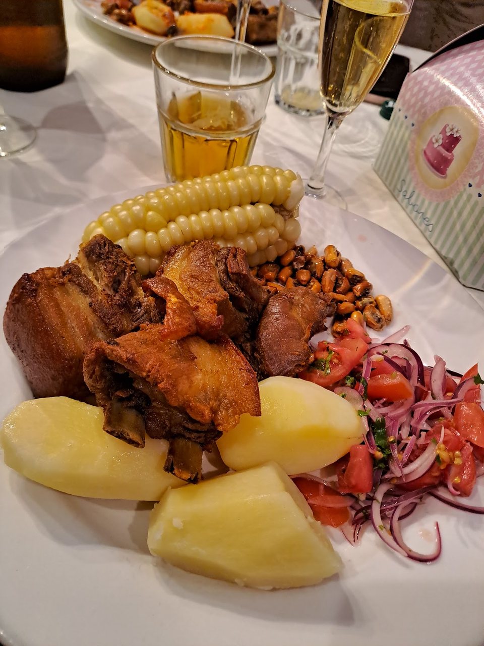 Plato de chicharrón con mote, papas y zarza criolla, especialidad de la casa